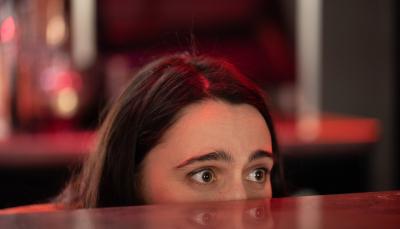 Kat Sadler as Josie peering over the bar in 'Such Brave Girls'